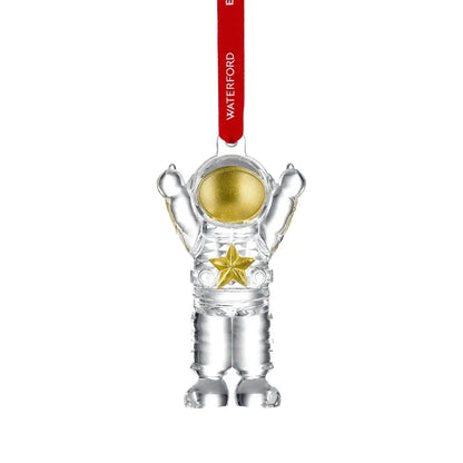Clear astronaut ornament with gold details and a red 'Waterford' tag on a white background