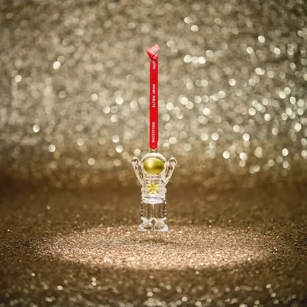 Clear astronaut figurine with a gold helmet on a red string 