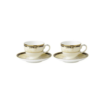 Two white tea cups with gold trim and saucers on a white background