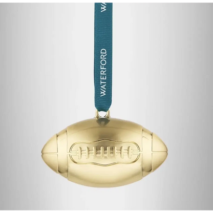 Gold football-shaped ornament with a blue ribbon and 'Waterford' text on a light gray background