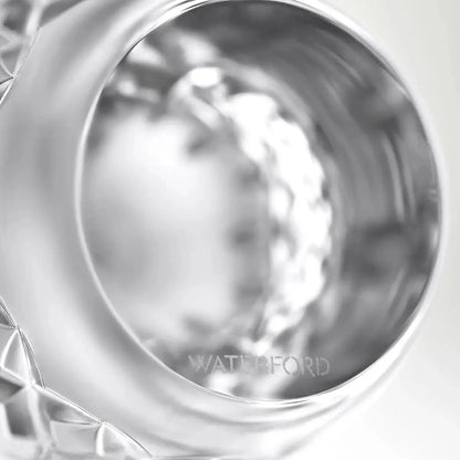 Close-up of a polished silver-toned cup or tumbler with a faceted cut-glass base, showing the engraved brand name WATERFORD near the rim.
