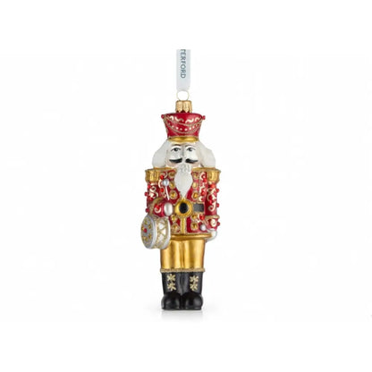 Decorative Christmas ornament resembling a nutcracker with gold and red details on a white background.