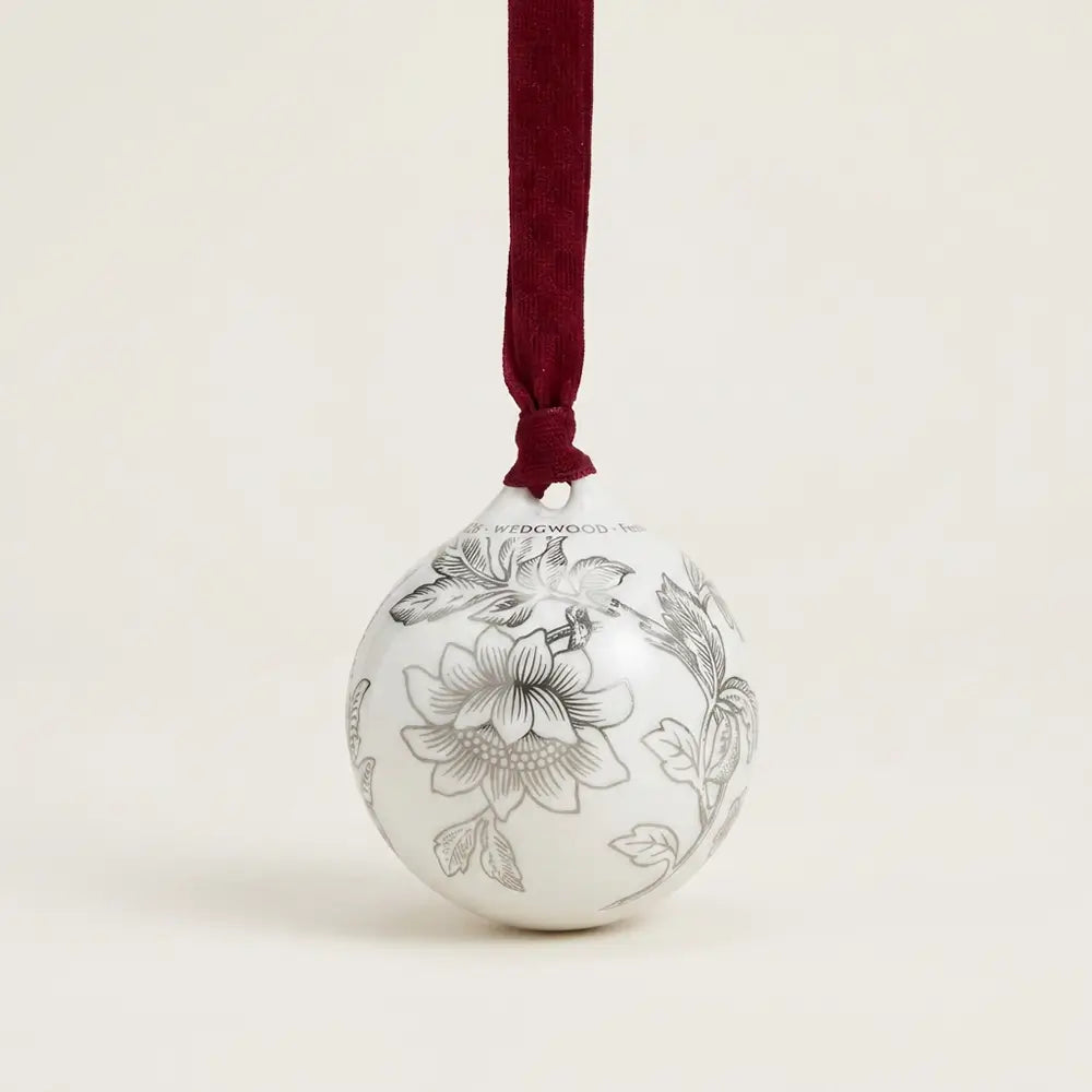 Decorative ornament with floral patterns and a red ribbon on a beige background
