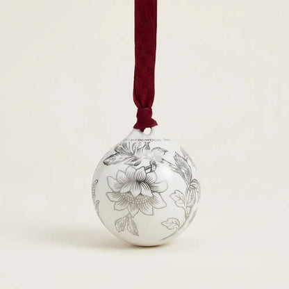 Decorative ornament with floral patterns and a red ribbon on a beige background