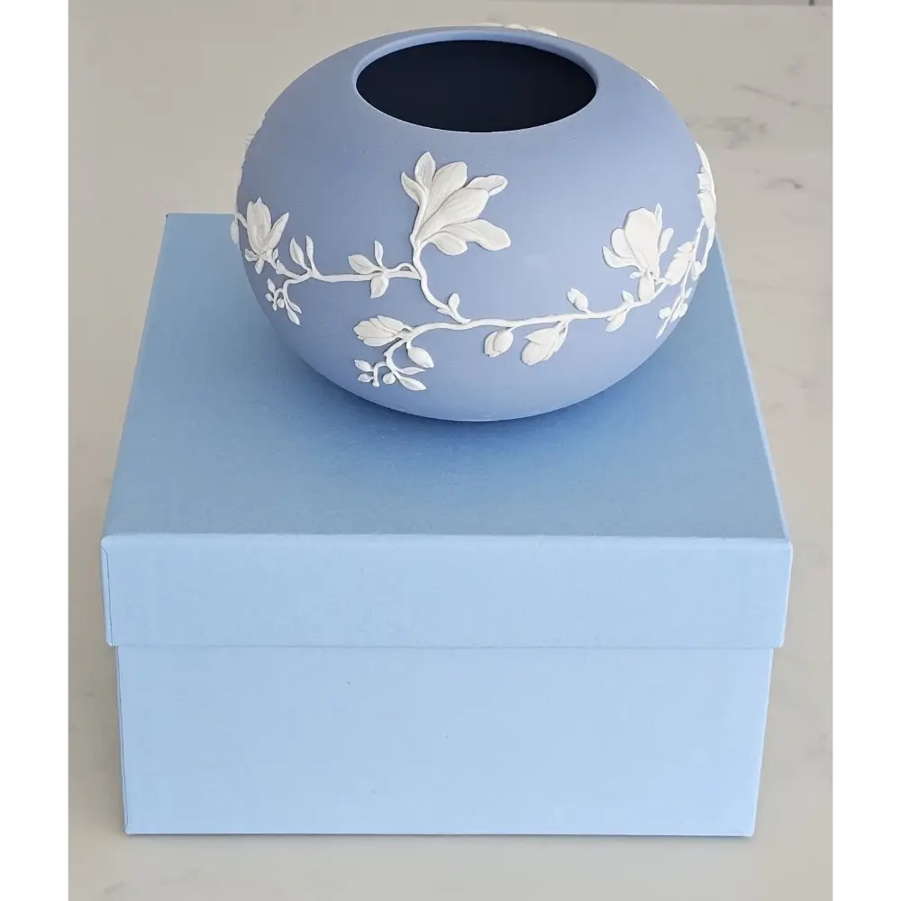 Decorative vase with floral patterns on a matching blue box