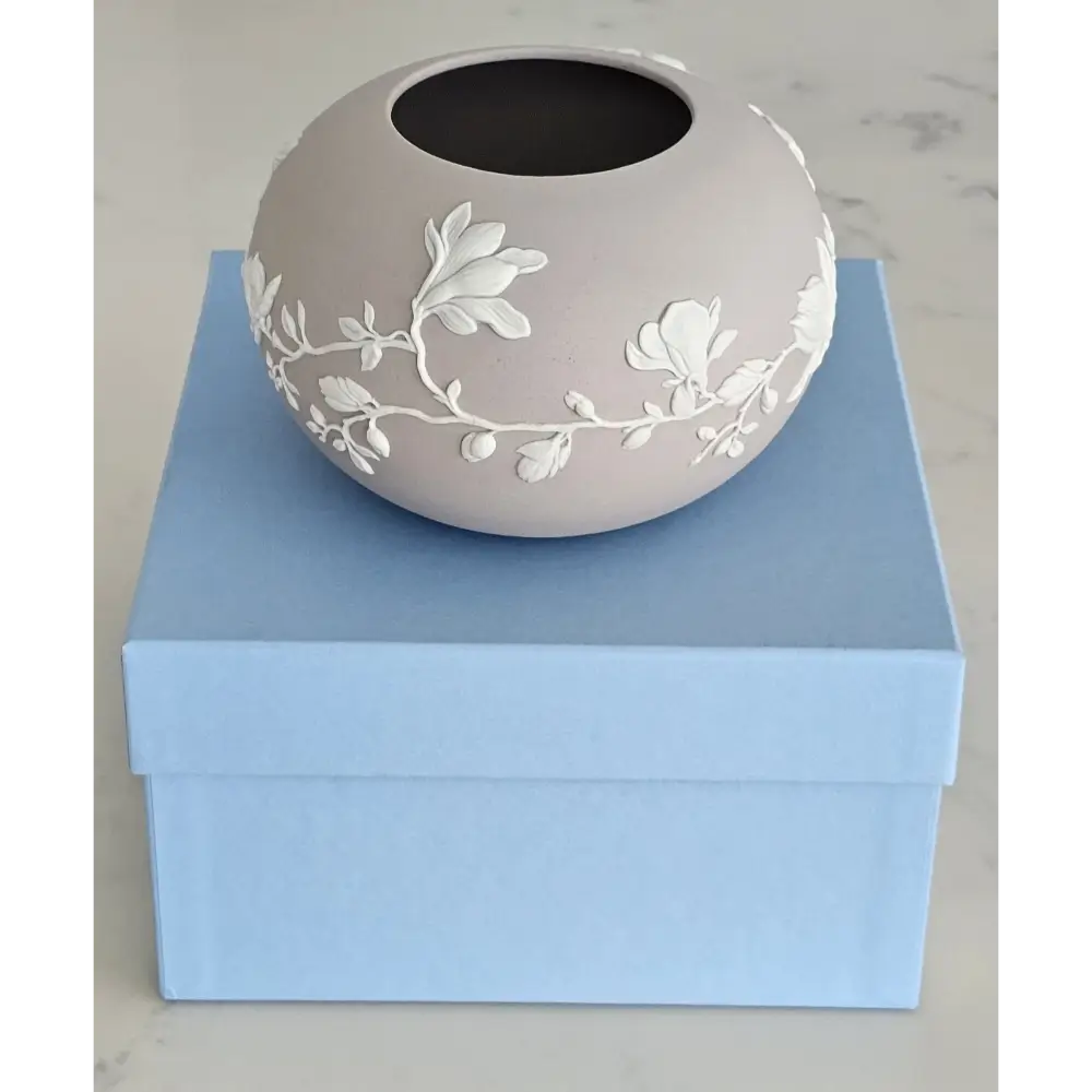 Decorative ceramic vase with floral patterns on a light blue box