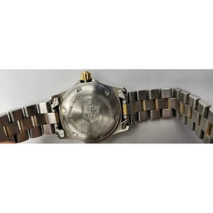 Close-up of a silver watch with a visible brand logo 