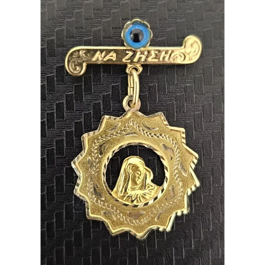 Gold pendant with a central figure on a black textured background