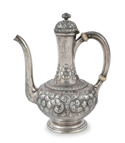 An ornate silver teapot with intricate floral and scrollwork embossed patterns, featuring a curved handle, a long spout, and a decorative lid, shown against a plain white background from our Antique & Vintage Collectibles Australia collection