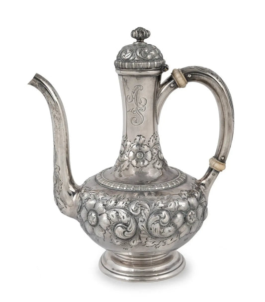 An ornate silver teapot with intricate floral and scrollwork embossed patterns, featuring a curved handle, a long spout, and a decorative lid, shown against a plain white background from our Antique & Vintage Collectibles Australia collection