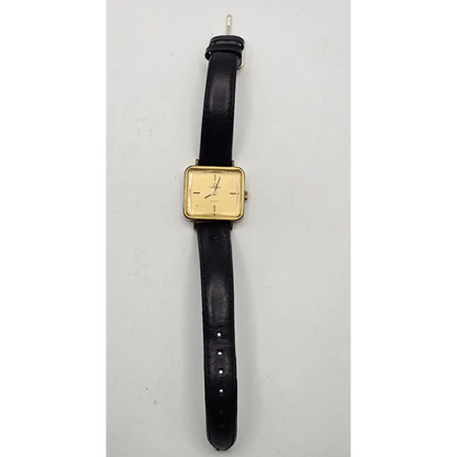 Vintage watch with black strap and gold case on a gray background