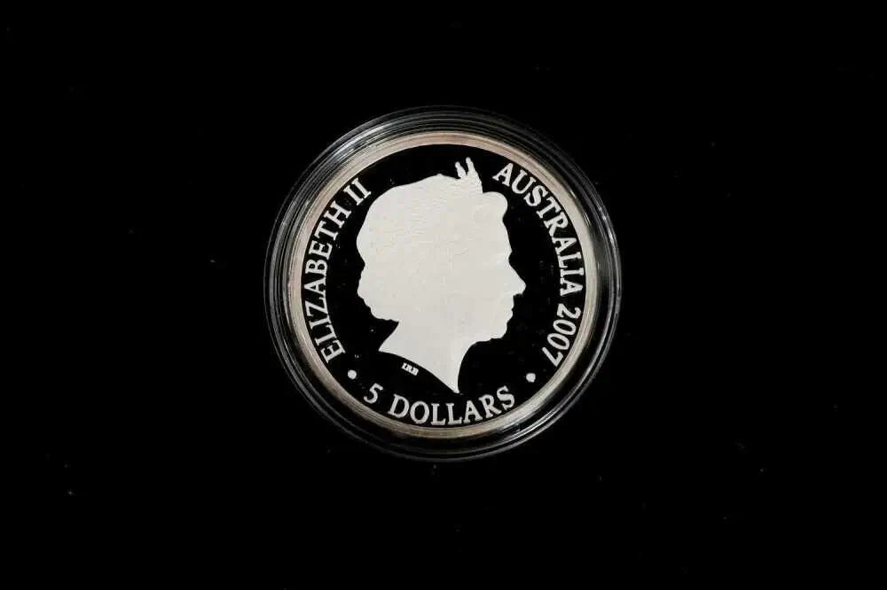 A 2007 Australian 5 dollar coin featuring Queen Elizabeth II's profile, housed in a clear protective capsule against a solid black background.