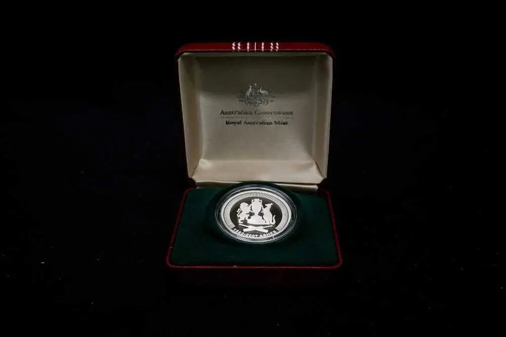 An Australian 10-year silver coin presented in an open red velvet display box with a green cushion, photographed against a solid black background.