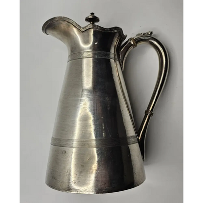 Silver pitcher on a gray background