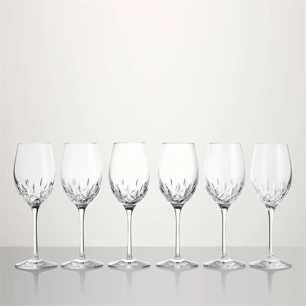 Six clear cut-crystal wine glasses arranged in a row on a light gray reflective surface against a light gray background from our Waterford Crystal Australia collection 