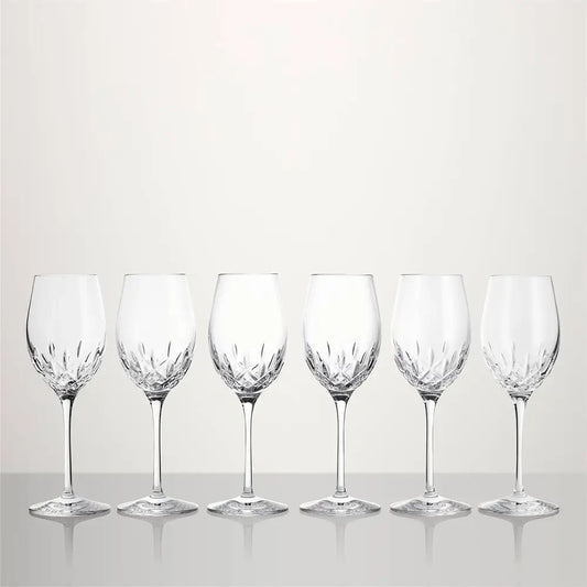 Six clear cut-crystal wine glasses arranged in a row on a light gray reflective surface against a light gray background from our Waterford Crystal Australia collection 